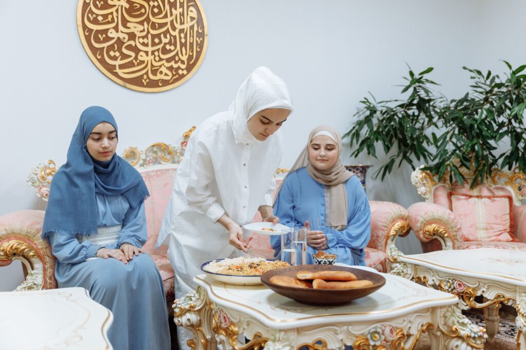 Muslim women preparing and enjoying iftar meal during Ramadan indoors
